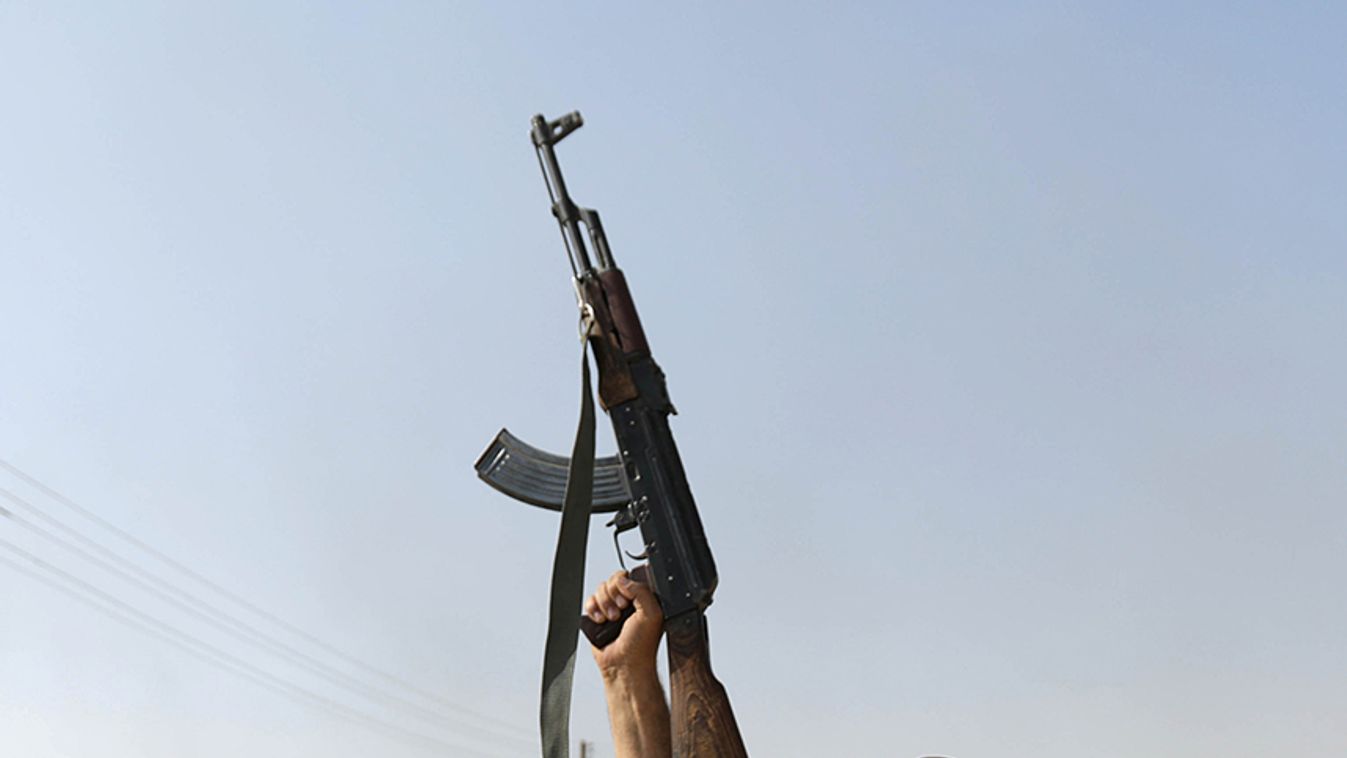 A Turkey-backed Syrian rebel fighter holds up a weapon in the town of Tal Abyad
