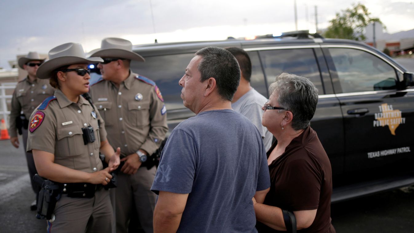 A couple look on after a mass shooting at a Walmart in El Paso