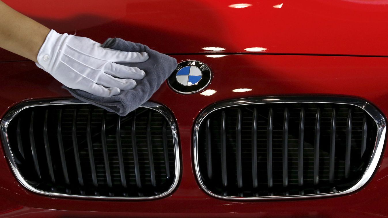 A staff cleans the bonnet of BMW 118i car during the Imported Auto Expo in Beijing
