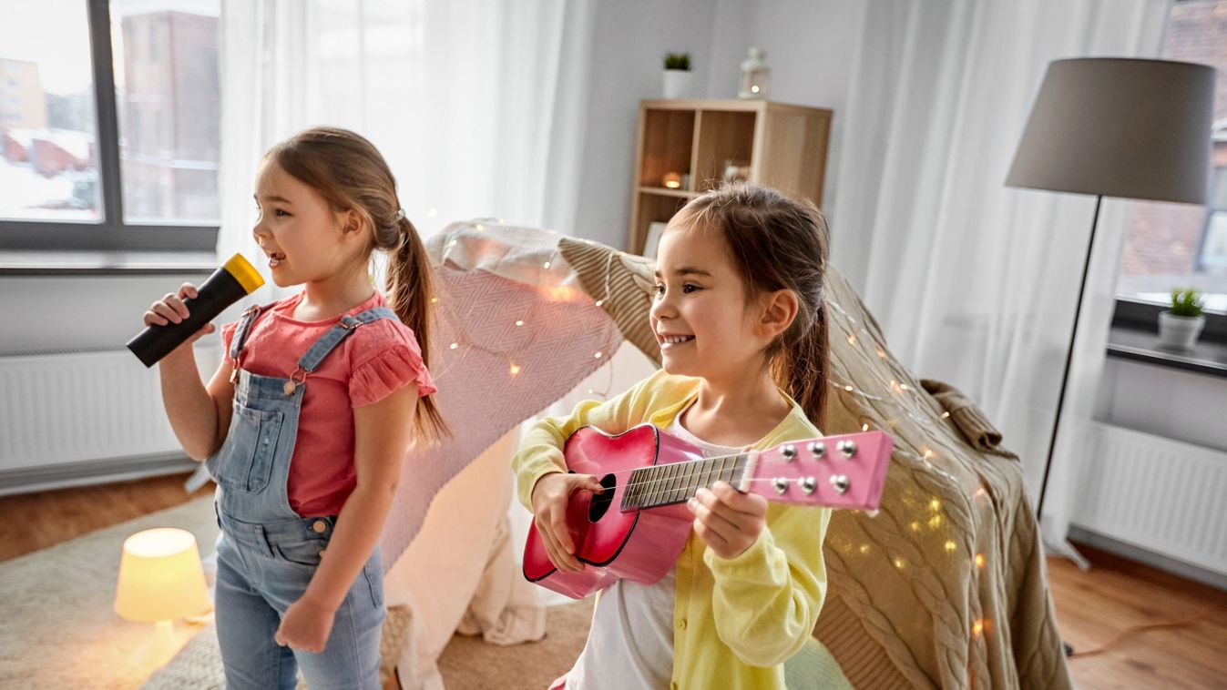 girls with guitar and microphone playing at home