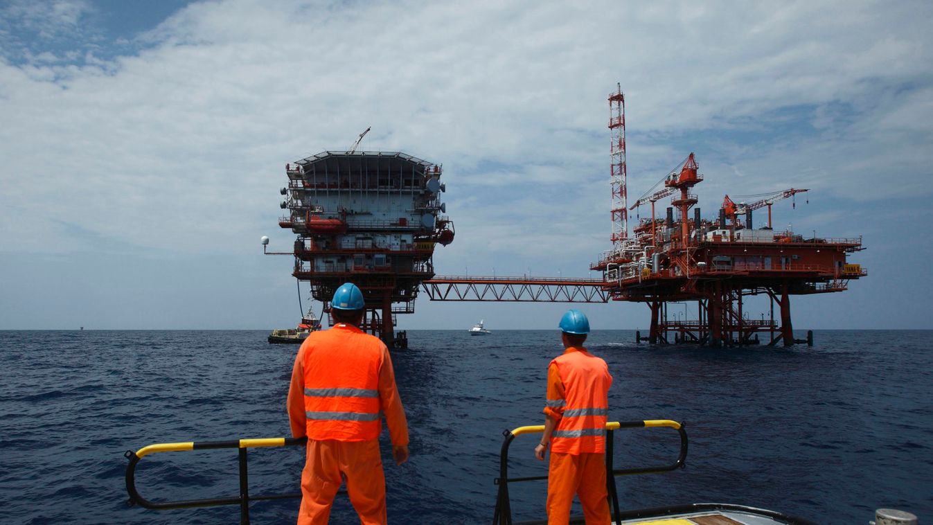 Ina Agip workers look at an oil platform in the Adriatic Sea