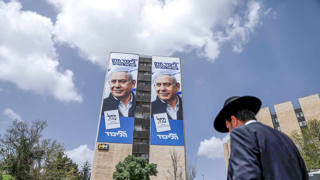 An ultra-Orthodox Jewish man walks past a Likud election campaign poster depicting Israeli Prime Minister Benjamin Netanyahu in Jerusalem