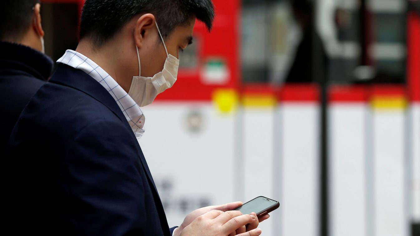 A man wears a protective mask as he looks at his mobile phone, following the outbreak of the new coronavirus, in Hong Kong