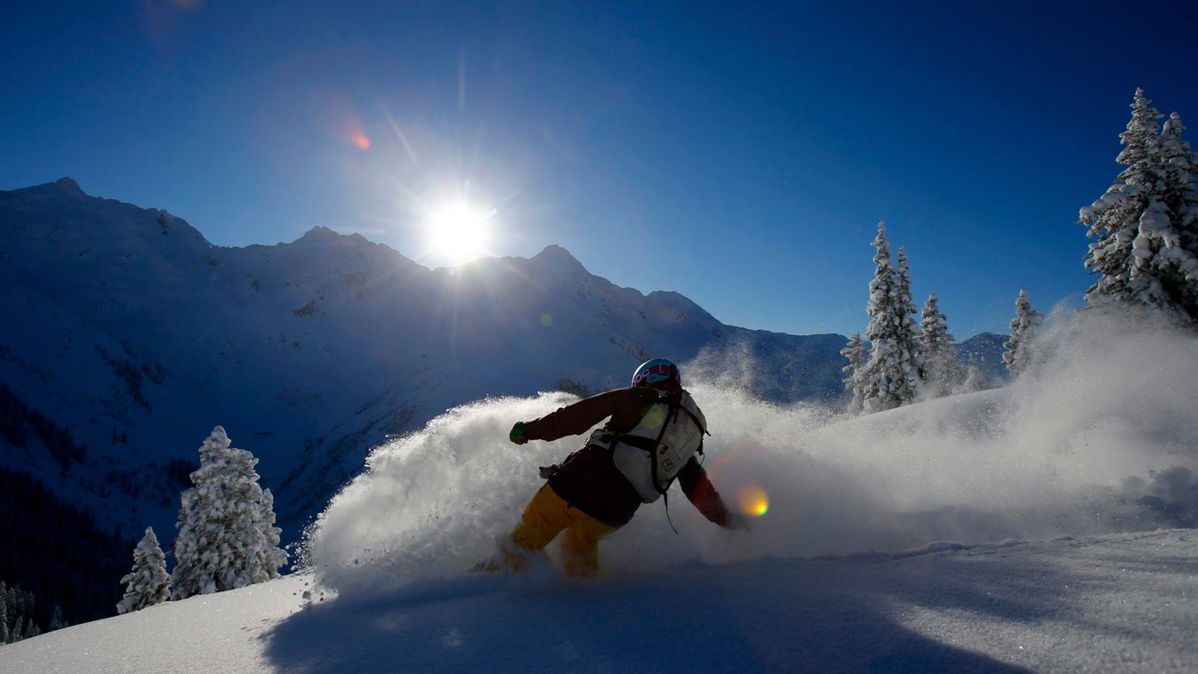 A snowboarder makes a turn on a sunny winter day in the western Austrian ski resort of Sonnenkopf mountain in Langen am Arlberg
