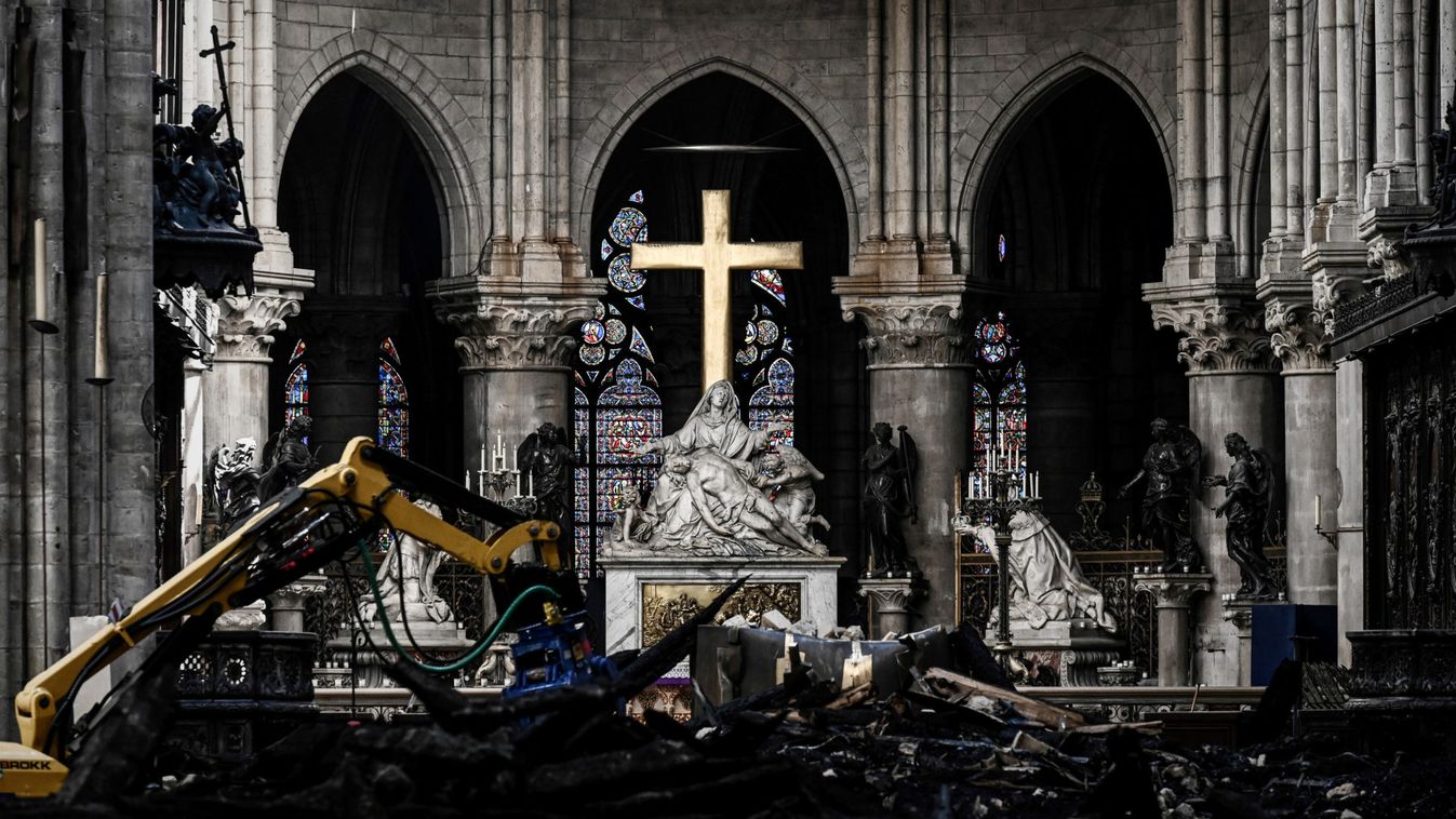 A picture shows rubbles and the cross at the altar, inside the the Notre-Dame Cathedral after it sustained major fire damage from the previous month, during the visit of Canadian Prime Minister Justin Trudeau in Notre-Dame Cathedral in Paris