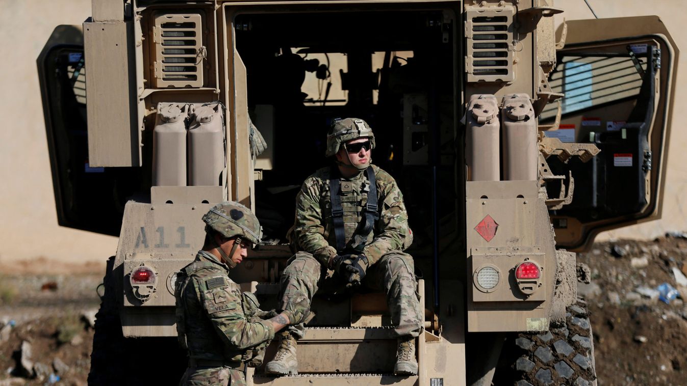 US army soldiers sit next a military vehicle in the town of Bartella