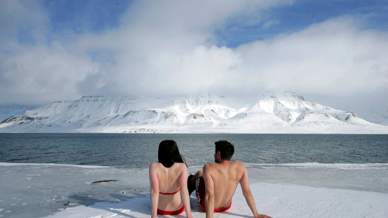 Climate activists Lesley Butler and Rob Bell "sunbathe" on the edge of a frozen fjord in the Norwegian Arctic town of Longyearbyen
