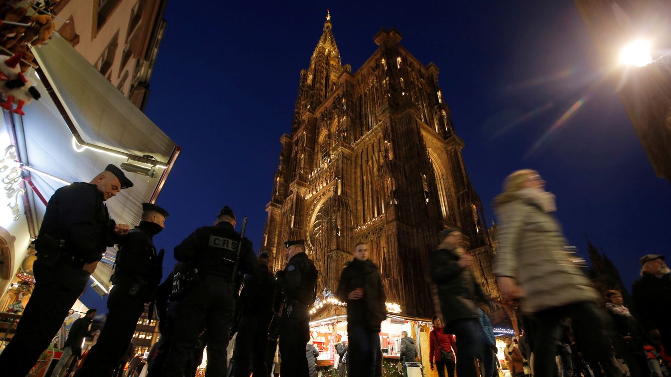 French police officers patrol the area as tourists visit the traditional Christmas market near Strasbourg Cathedral
