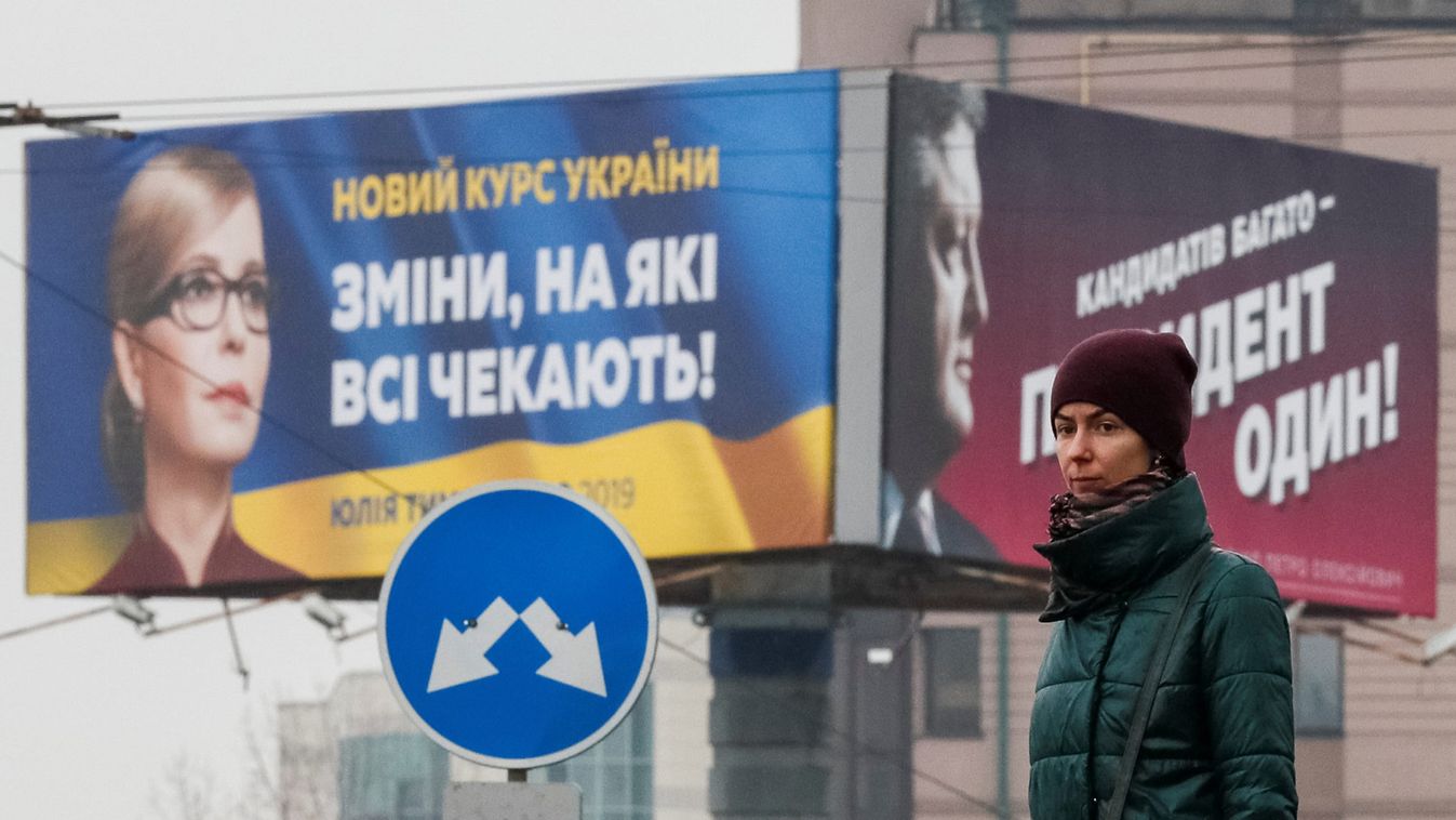 Woman stands in front of pre-election posters of opposition politician Yulia Tymoshenko and Ukrainian President Petro Poroshenko in Kiev