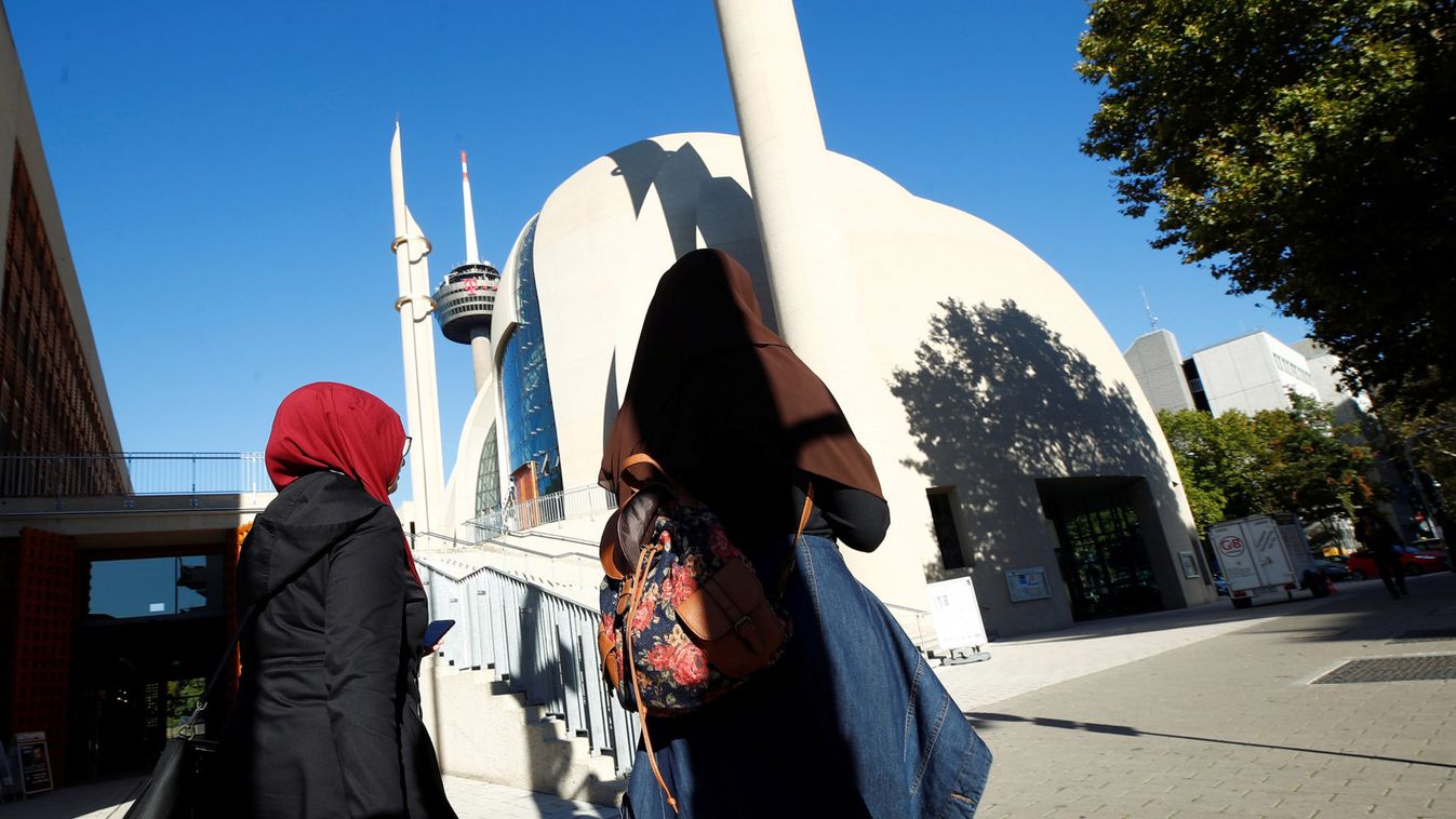 Women walk in front of Cologne Central Mosque, in Cologne