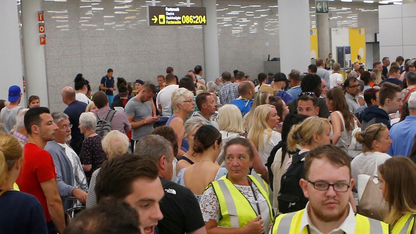 Passengers are seen at Thomas Cook check-in points at Mallorca Airport after the world's oldest travel firm collapsed, in Palma de Mallorca