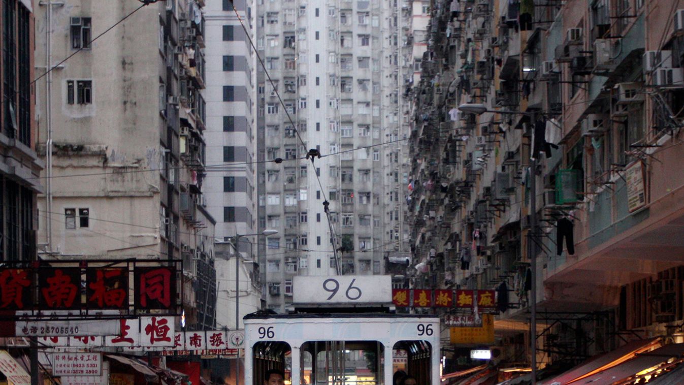 A tram passes by a marketplace in downtown Hong Kong