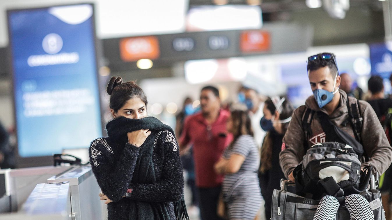A passenger covers her face as she walks at Galeao international airport during the coronavirus disease (COVID-19) outbreak in Rio de Janeiro