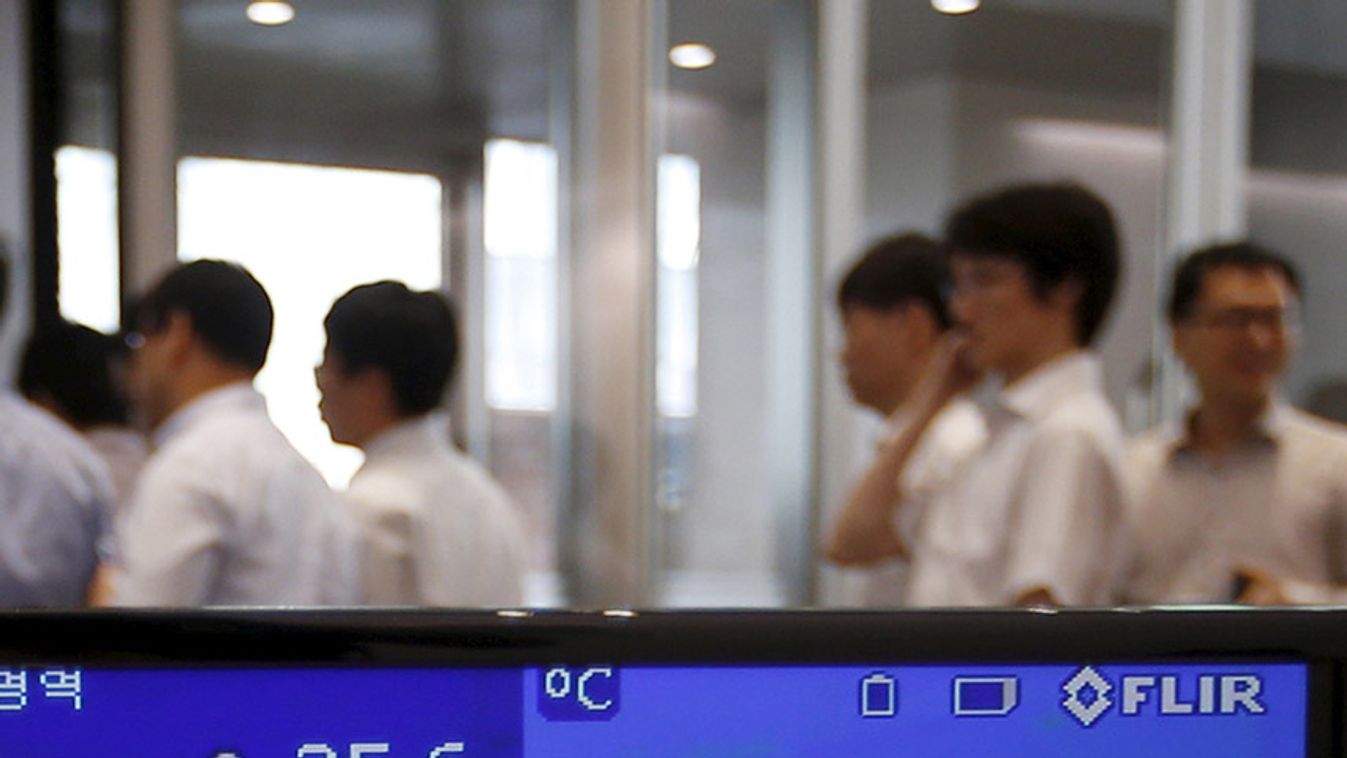 Employees walk past a thermal imaging camera at an office building in central Seoul