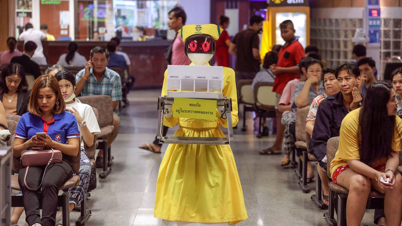 A robot wearing a nurse costume carries medical documents at Mongkutwattana General Hospital in Bangkok