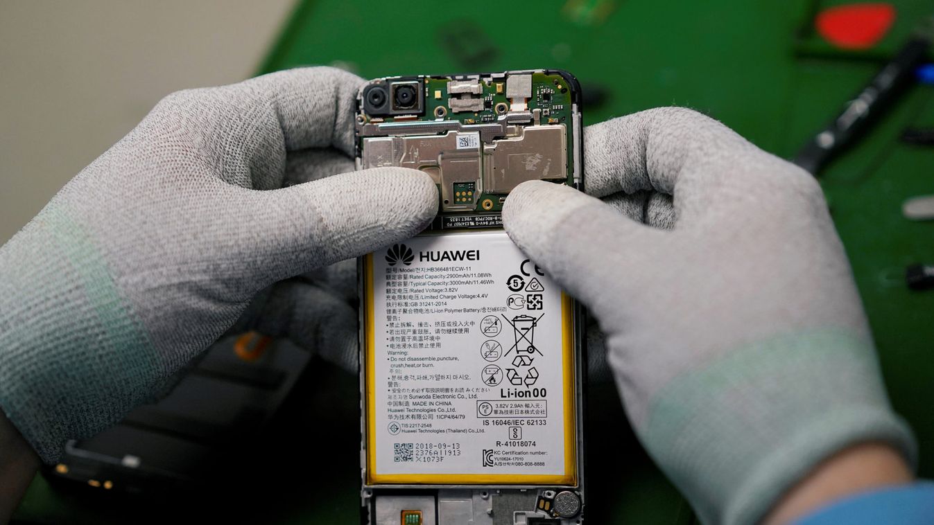 A worker checks a phone in a Huawei store in Madrid