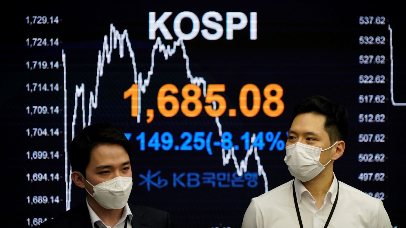 Currency dealers walk past an electronic board showing the Korea Composite Stock Price Index (KOSPI) at a dealing room of a bank in Seoul