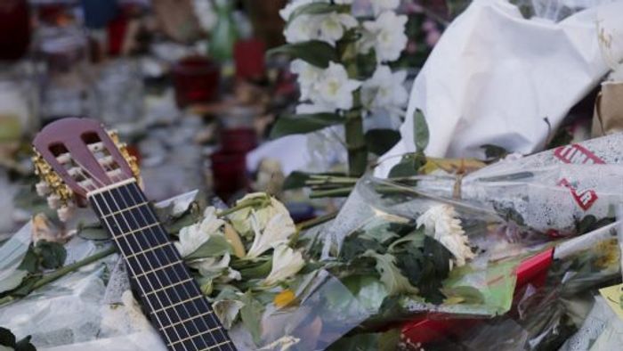 A guitar with a message bearing France's national motto „Liberte, Egalite, Fraternite”, is seen among flowers left in tribute to victims near the Bataclan concert hall, one of the sites of last week's deadly attacks in Paris