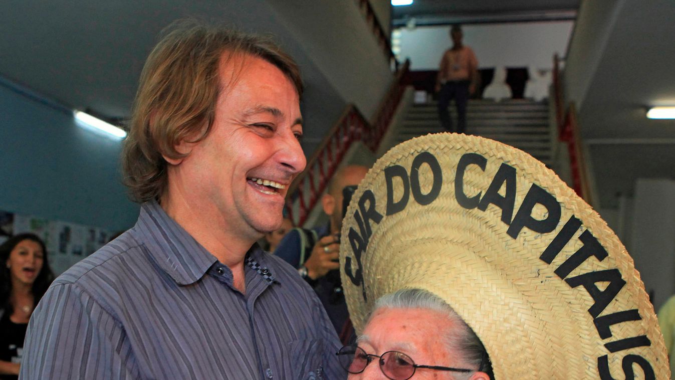 Former Italian guerrilla Battisti dances with a woman during the World Social Forum in Porto Alegre