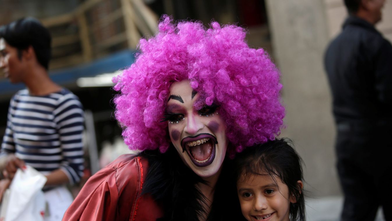 A participant dressed in drag poses for a picture with a child during the "Drag Queen Story Hour" event, which according to organizers involves participants reading stories to children for an hour, in downtown Monterrey