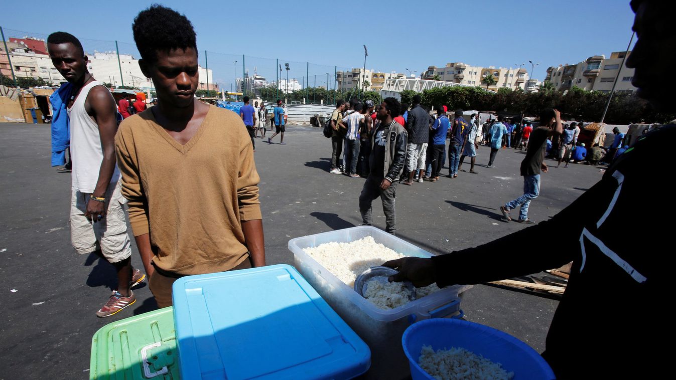 A man distributes food to African migrants at a makeshift home on the outskirts of Casablanca