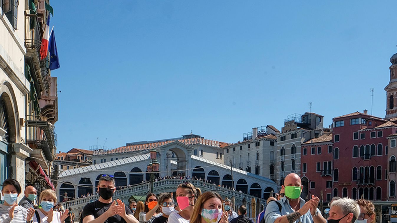 A rally organised by small business owners stops by the Rialto bridge to commemorate the health care workers, as Italy begins a staged end to a nationwide lockdown due to a spread of the coronavirus disease (COVID-19), in Venice