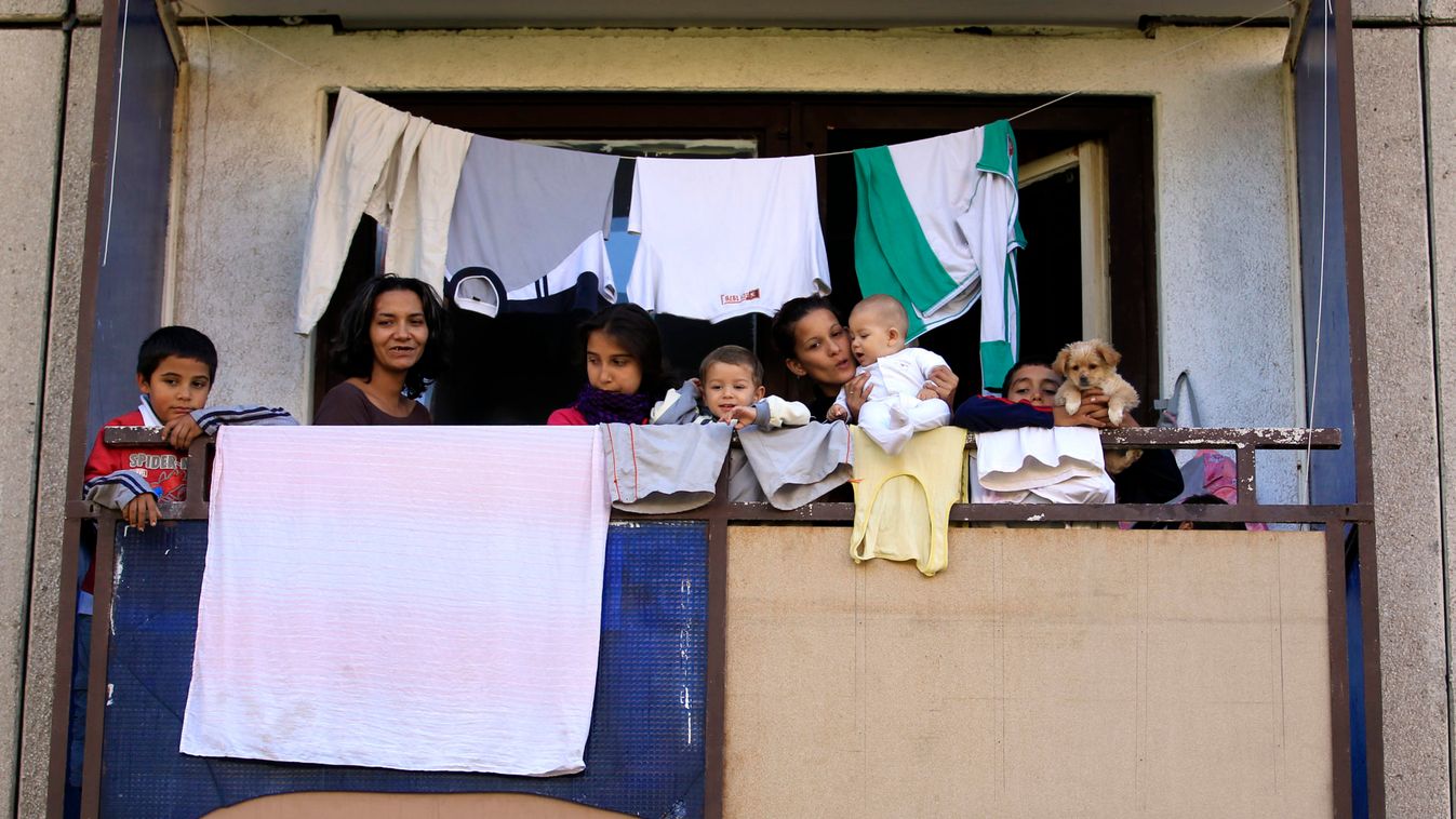Maria Gagy, a 26-year-old Roma woman, and her family stand at her apartment's balcony at the Avas apartment block in Miskolc