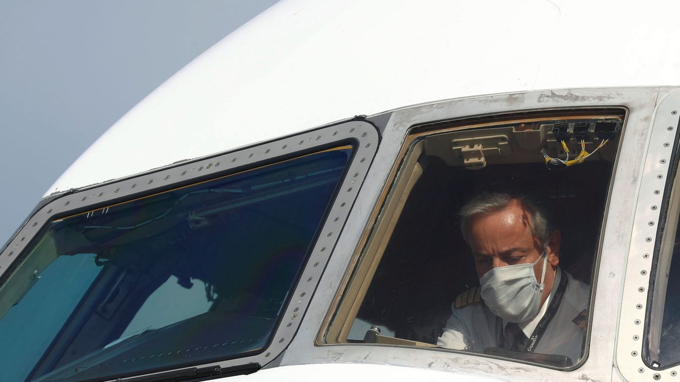 A pilot wearing a protective mask is seen in a cargo aircraft at Liege airport