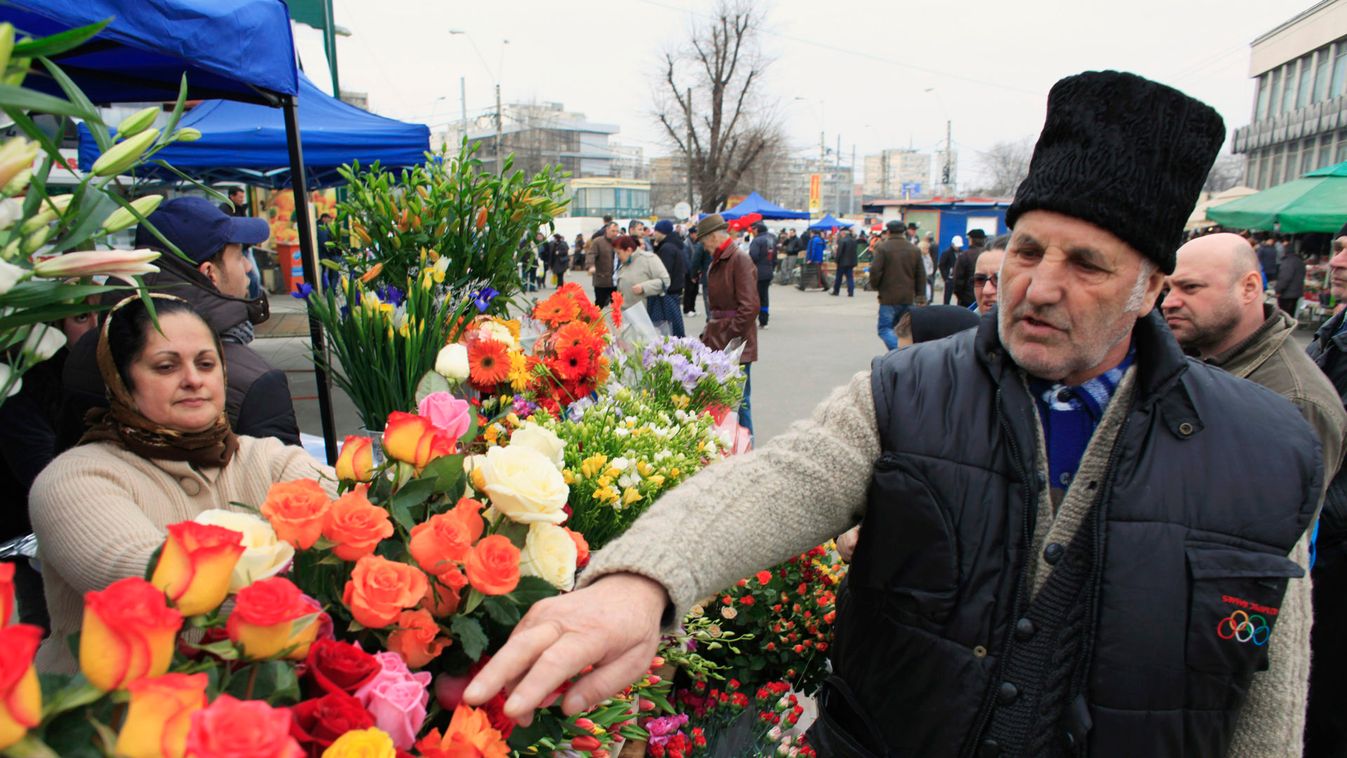 A man points to the roses he wants to purchase at an outdoor market on International Women's Day in Bucharest