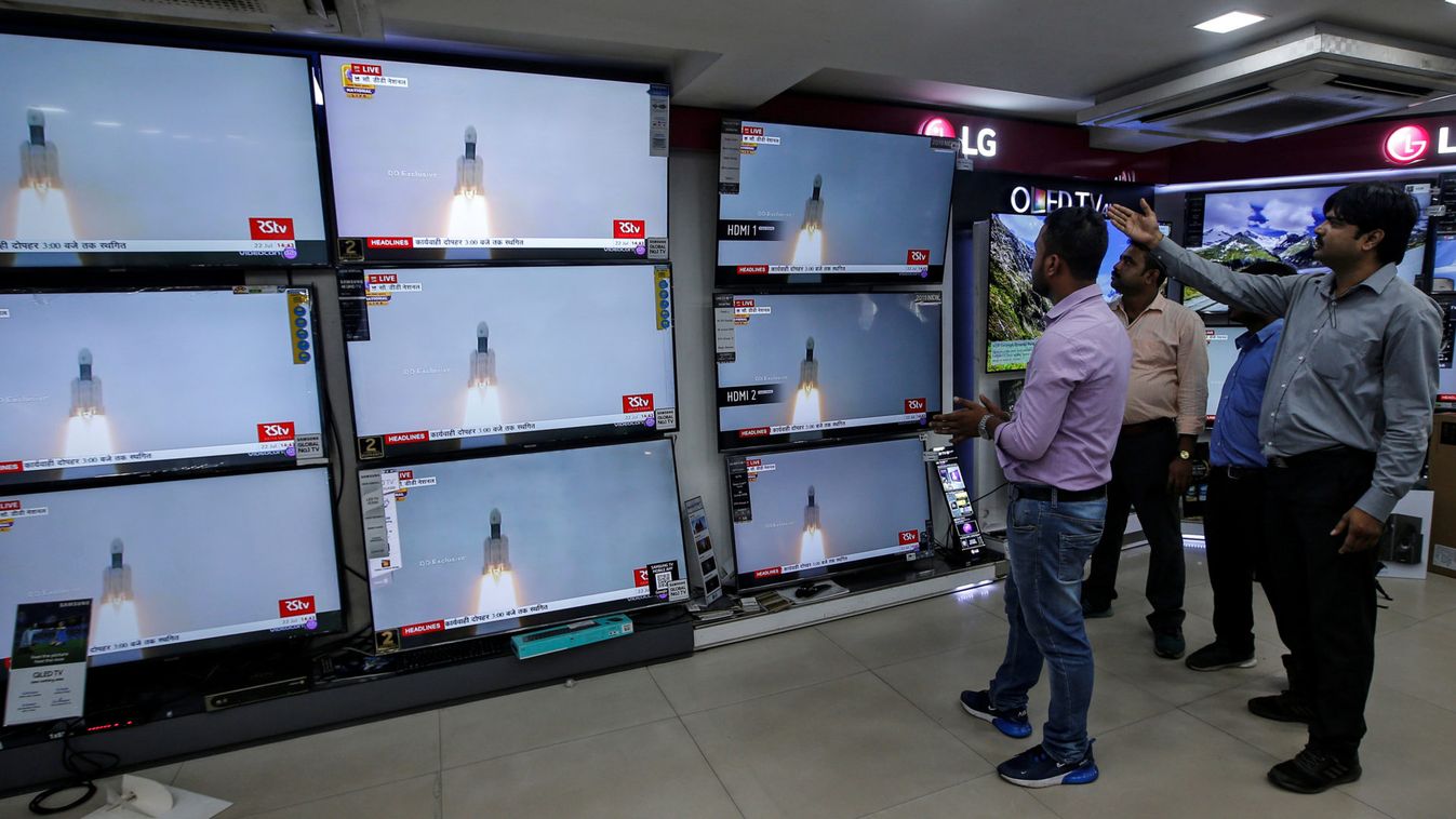 People celebrate as they watch a live broadcast of India's second lunar mission, Chandrayaan-2, inside an electronics showroom in Kolkata