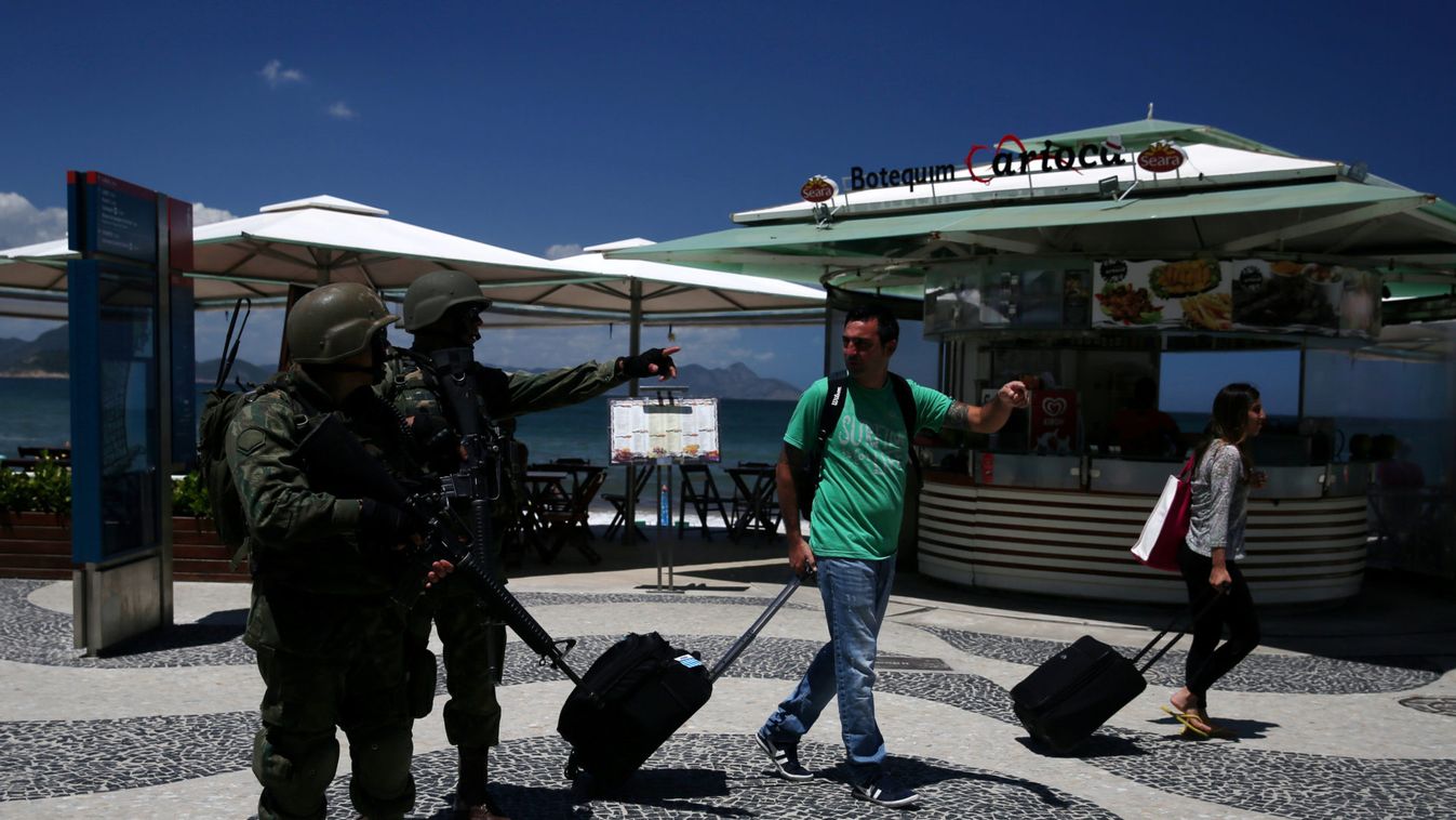 Brazilian navy soldiers give directions to tourists as they patrol the Copacabana beach in Rio de Janeiro