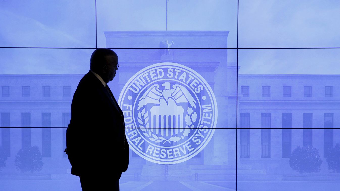A guard walks in front of a Federal Reserve image before press conference in Washington