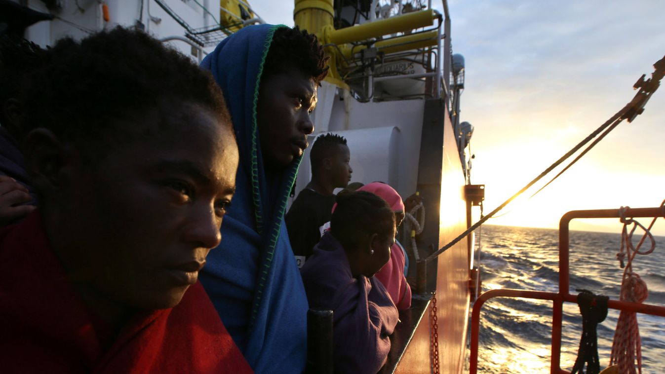 Migrants wait to disembark from the MV Aquarius rescue ship, after being rescued by SOS Mediterranee organisation, in the Sicilian harbour of Trapani