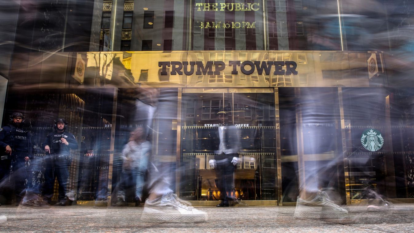 Pedestrians walk past and take pictures in front of the Trump Tower on 5th Avenue in the Manhattan borough of New York
