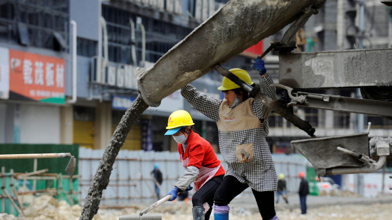 Workers wearing face masks work at a construction site in Renhuai, Guizhou