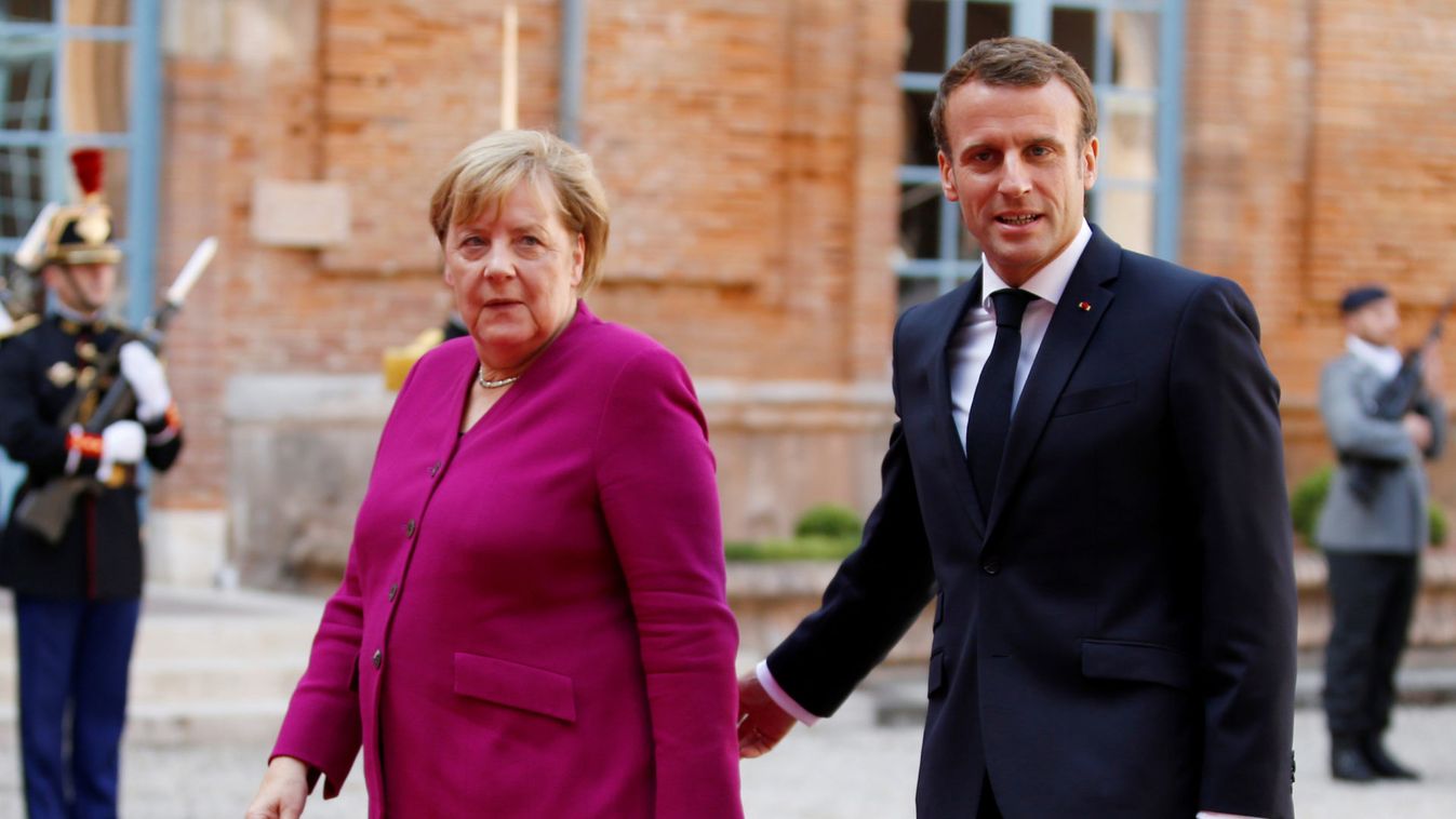 French President Emmanuel Macron welcomes German Chancellor Angela Merkel before a joint Franco-German cabinet meeting in Toulouse