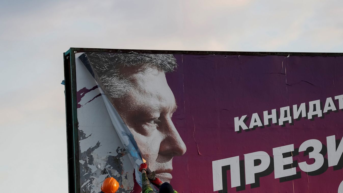 Municipal workers remove an election poster of Ukrainian President and presidential candidate Petro Poroshenko in Slaviansk