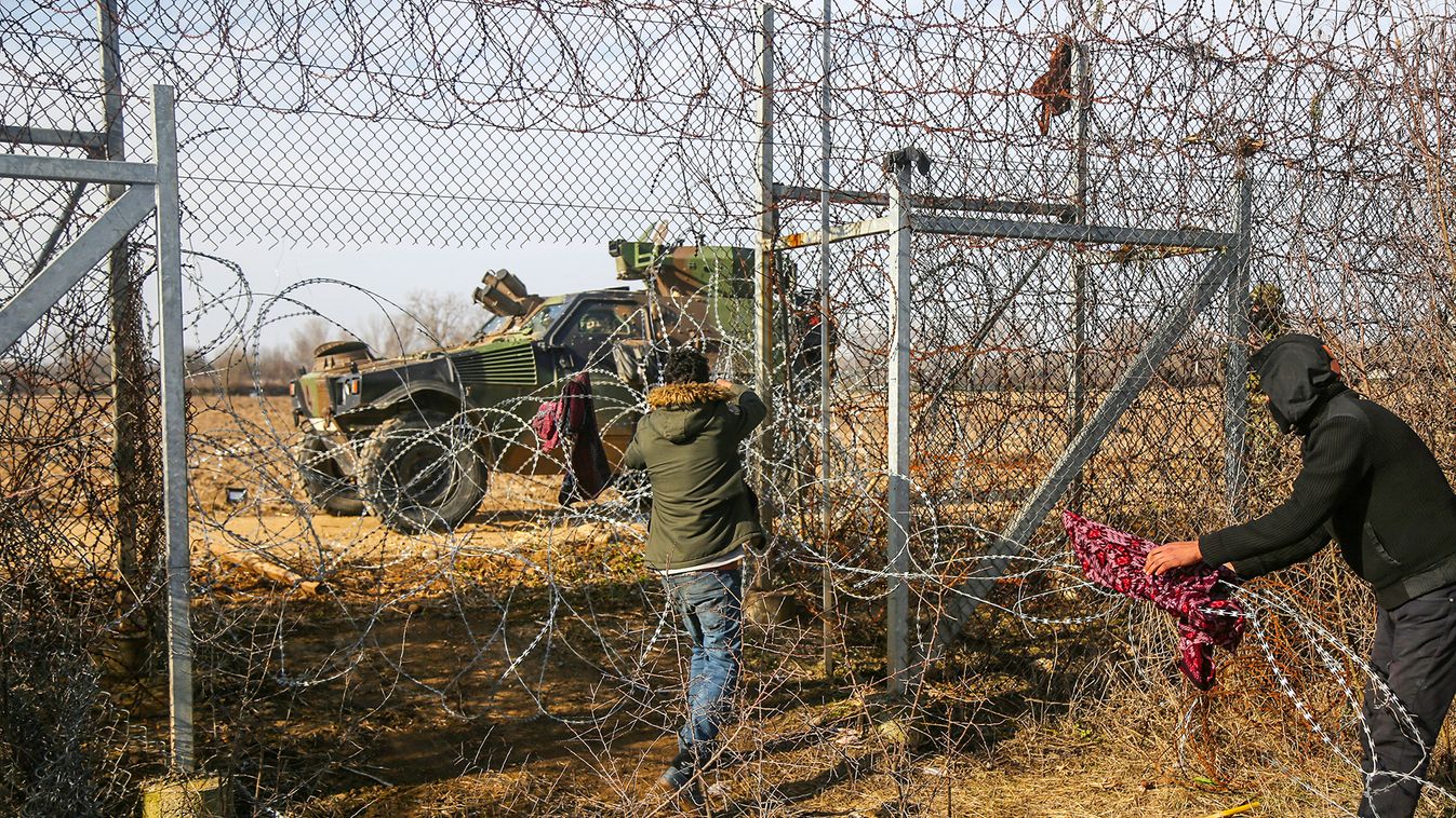 Migrants try to bring down part of a border fence on the Turkish-Greek border at Turkey's Pazarkule border crossing with Greece's Kastanies, near Edirne