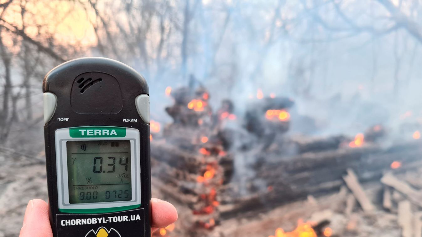 A geiger counter measures a radiation level at a site of fire burning in the exclusion zone around the Chernobyl nuclear power plant