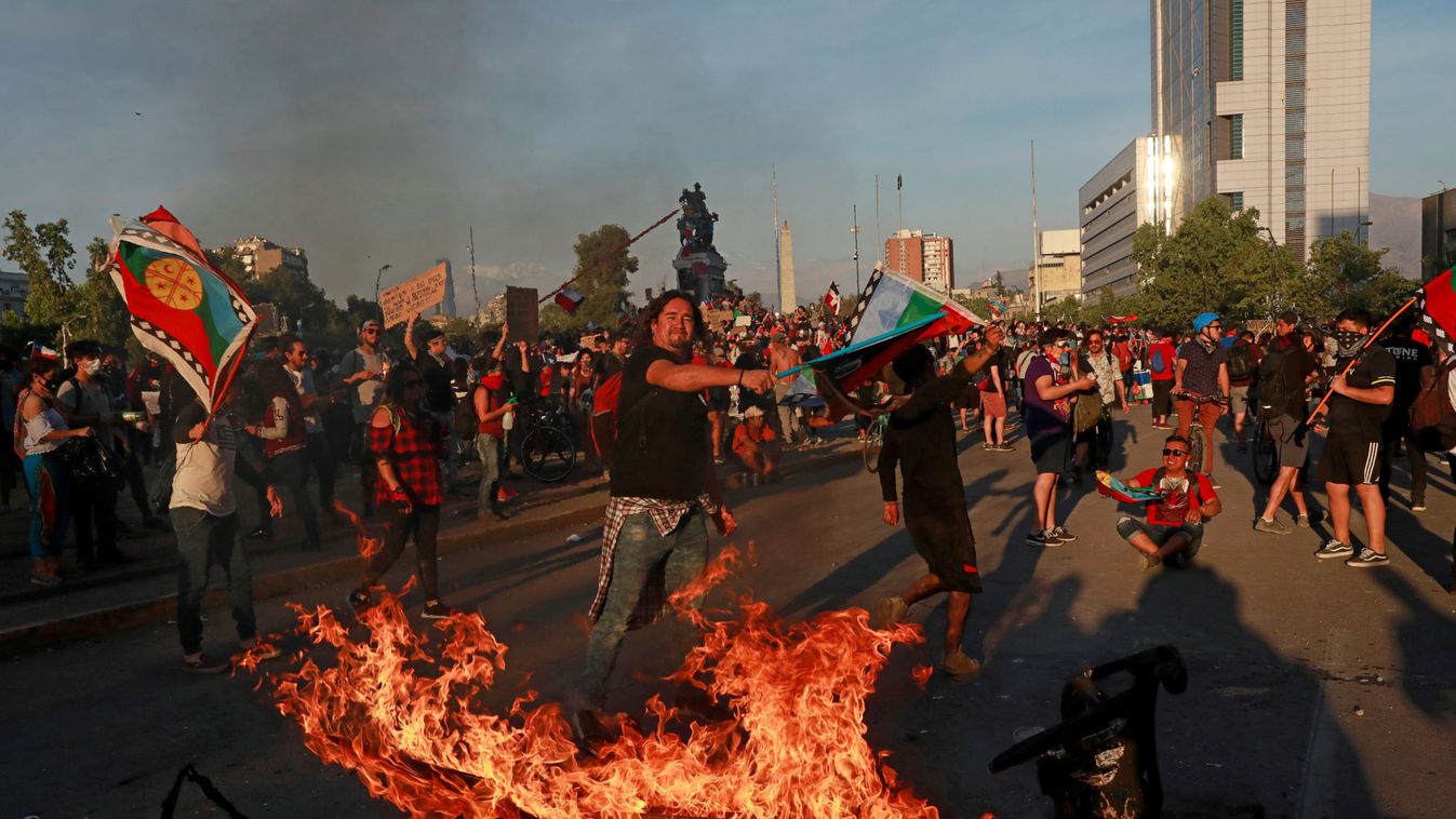 Demonstrators wave a Mapuche flag during a protest against Chile's state economic model in Santiago