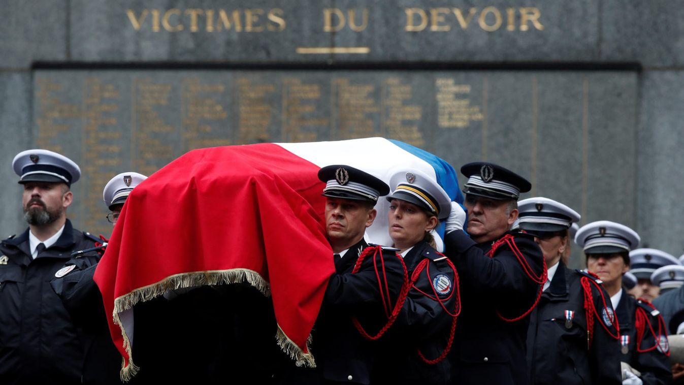 One of the flag-draped coffins of the late three police officers and an administrative worker is carried by colleagues during a ceremony to honour four victims of Paris police attack