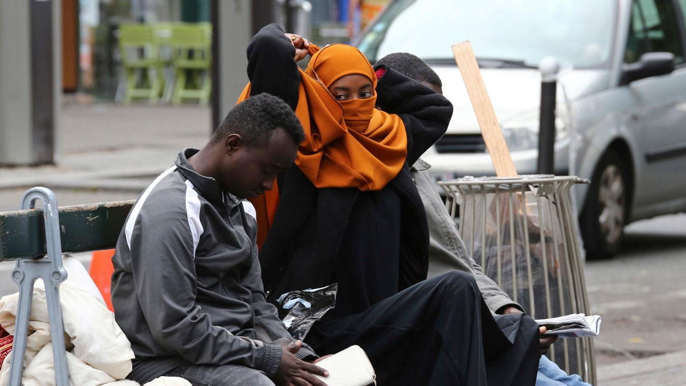Migrants are seen at a makeshift camp on a street in Paris