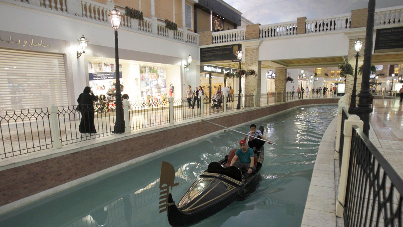 A man takes a boat ride through a canal inside Villagio Mall, a popular shopping area in Doha's west end