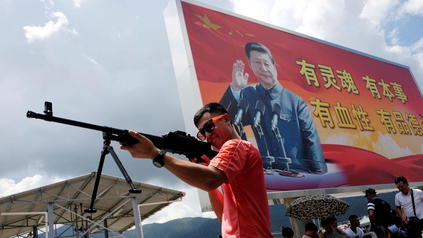 A visitor plays with a gun at a People's Liberation Army airbase in Hong Kong