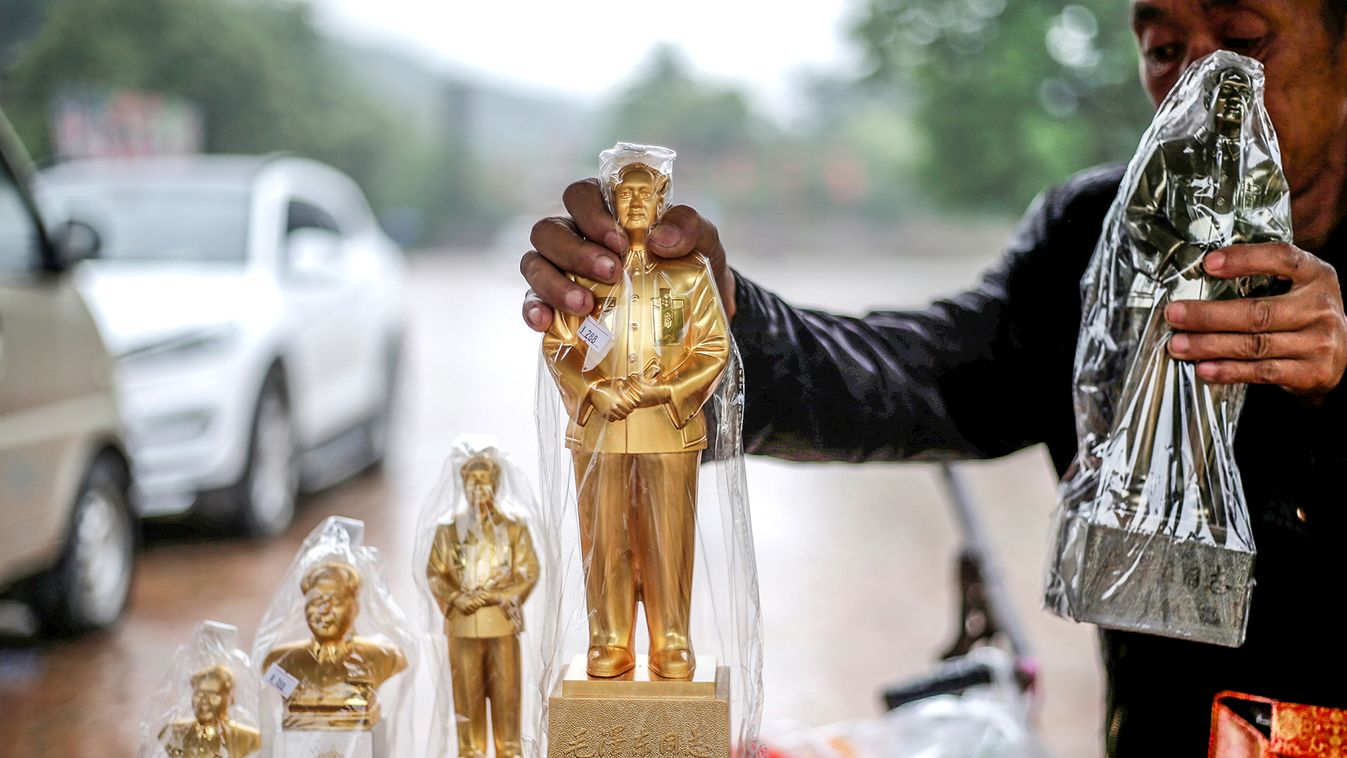A vendor holds a statue of late Chinese chairman Mao Zedong displayed for sale outside a revolutionary site in Yanan, Shaanxi province