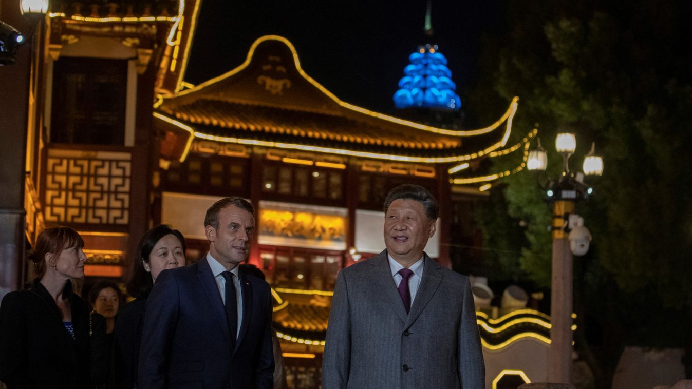 Chinese President Xi Jinping walks with with French President Emmanuel Macron after having dinner at the Yu Garden district in Shanghai