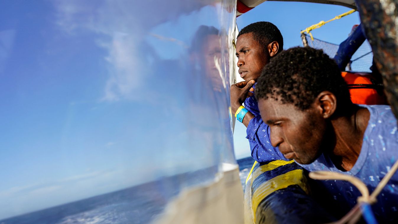 Migrants stand on board a NGO Proactiva Open Arms rescue boat in central Mediterranean Sea sailing to the Italian port of Taranto