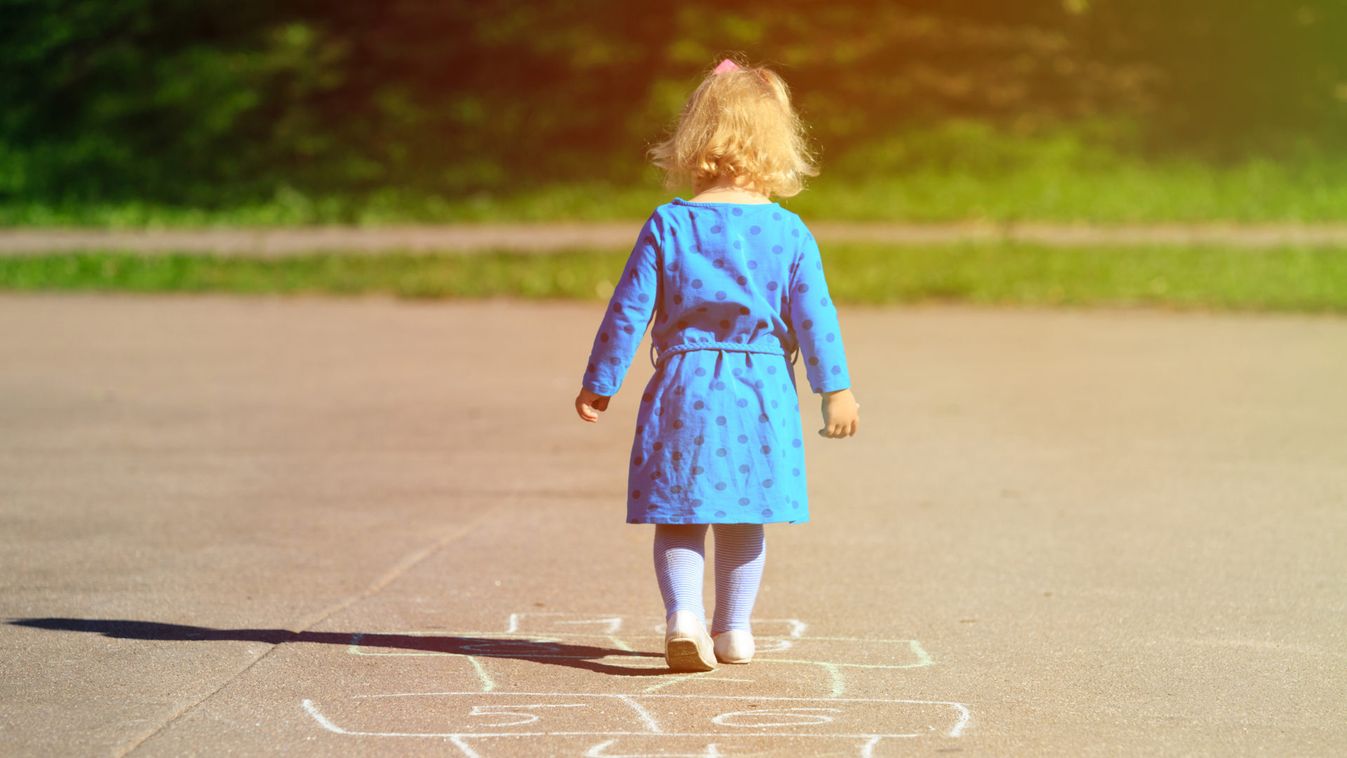 little girl playing hopscotch on playground