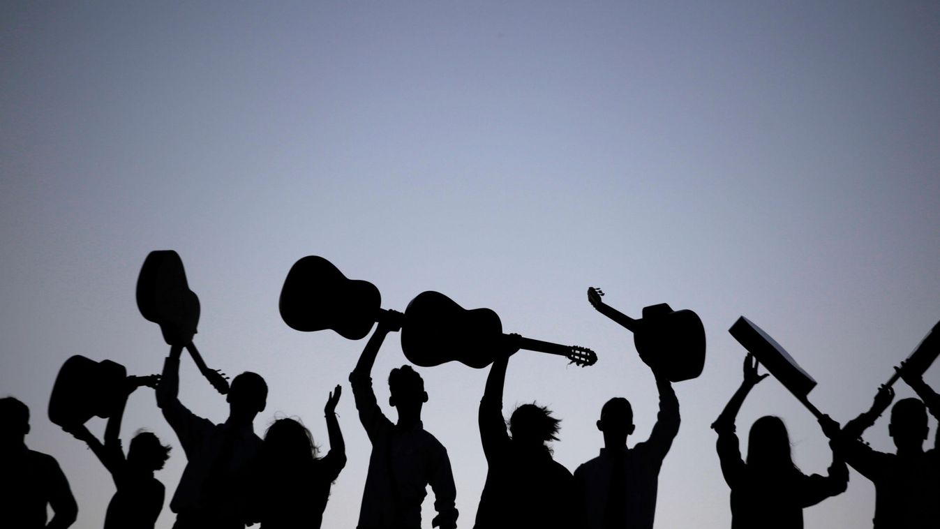 Members of a Rondalla, an ensemble of plectrum and stringed instruments, are silhouetted while holding up their guitars after performing in Ciudad Juarez