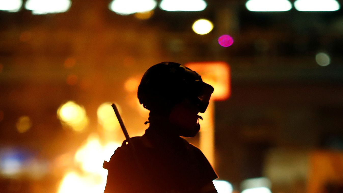 A protester is seen in front of a fire in the Mong Kok area in Hong Kong